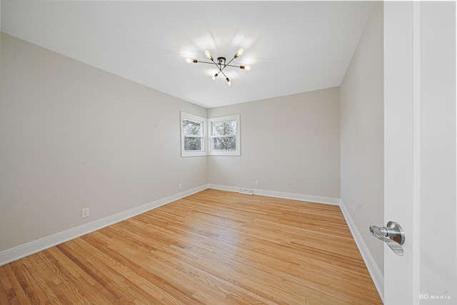 unfurnished room featuring light wood-style flooring, baseboards, visible vents, and a chandelier