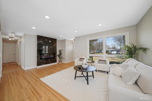 living room featuring attic access, recessed lighting, baseboards, and light wood finished floors