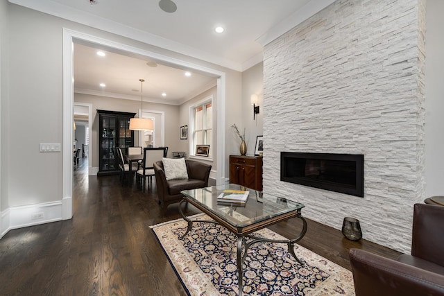 living room featuring baseboards, ornamental molding, wood finished floors, a fireplace, and recessed lighting