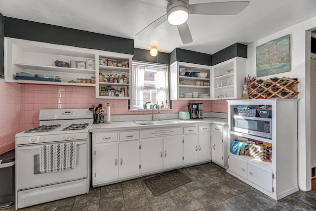 kitchen with open shelves, light countertops, white cabinets, a sink, and white range with gas stovetop