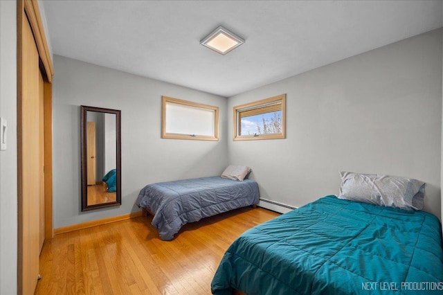 bedroom featuring a baseboard radiator and wood finished floors