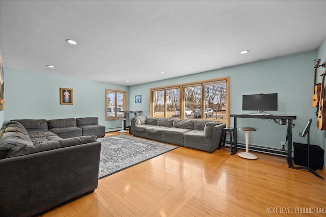 living room featuring baseboard heating, wood-type flooring, and recessed lighting