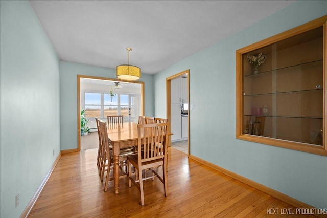 dining room featuring light wood-style flooring and baseboards