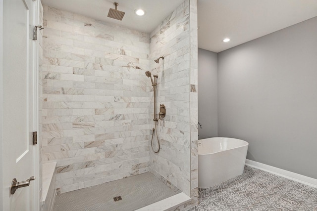 full bath featuring recessed lighting, a freestanding bath, a tile shower, and baseboards