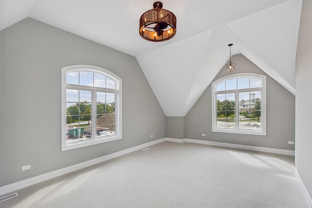 bonus room with lofted ceiling, a healthy amount of sunlight, light carpet, and baseboards