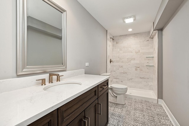 full bath with toilet, baseboards, tiled shower, and vanity