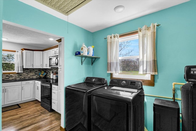 washroom featuring laundry area, washer and dryer, and wood finished floors