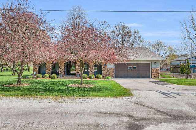 view of front of property featuring an attached garage, driveway, a front lawn, and fence