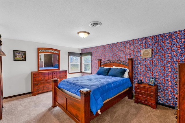 carpeted bedroom with visible vents, a textured ceiling, baseboards, and wallpapered walls