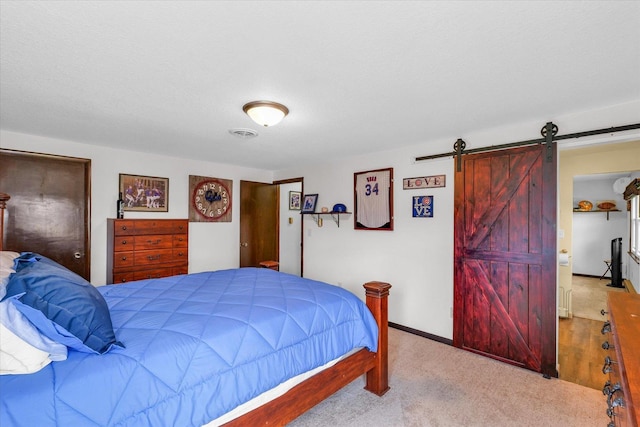 bedroom with carpet floors, visible vents, a barn door, a textured ceiling, and baseboards