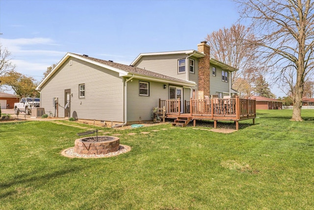 back of house featuring an outdoor fire pit, a yard, crawl space, a wooden deck, and a chimney