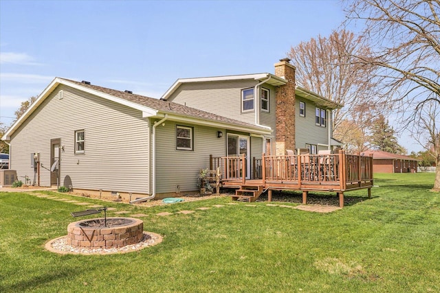 back of house featuring an outdoor fire pit, crawl space, a lawn, a wooden deck, and a chimney