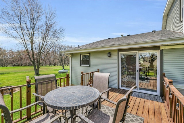 deck with outdoor dining space and a yard