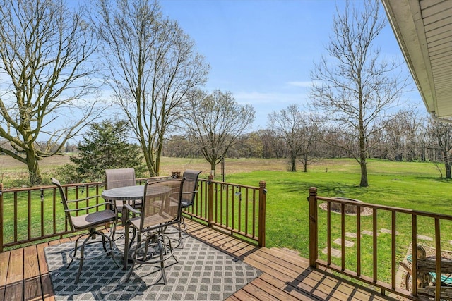 wooden deck with outdoor dining space and a yard