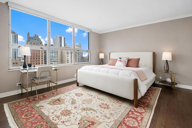 bedroom with crown molding, a view of city, baseboards, and wood finished floors