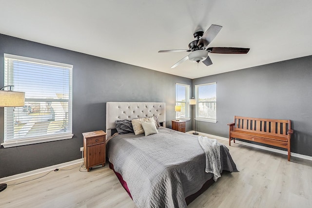 bedroom with light wood-style floors, ceiling fan, and baseboards