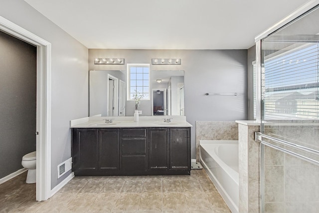 full bathroom featuring double vanity, a sink, toilet, and a bath