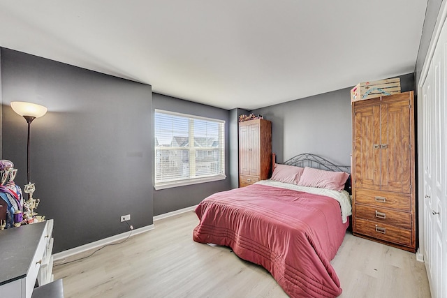 bedroom with light wood-style flooring and baseboards