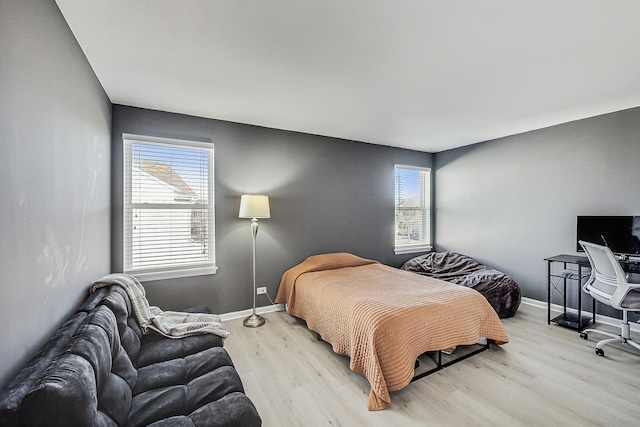 bedroom with light wood-type flooring and baseboards