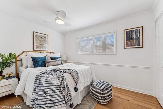 bedroom featuring baseboards, wood finished floors, a ceiling fan, and crown molding