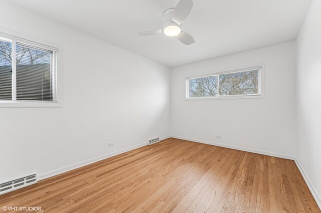 unfurnished room featuring light wood-style floors, visible vents, ceiling fan, and baseboards