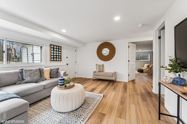 living room featuring light wood-type flooring, baseboards, and recessed lighting