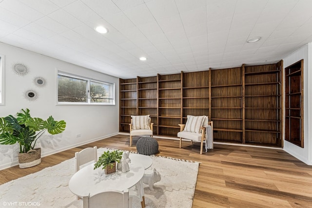 living area with light wood-style flooring, baseboards, and recessed lighting