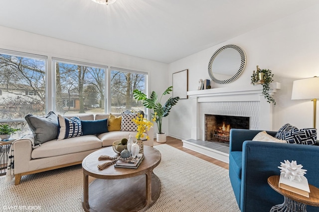 living area featuring a warm lit fireplace and wood finished floors