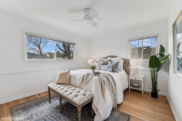 bedroom with a ceiling fan, baseboards, crown molding, and light wood finished floors