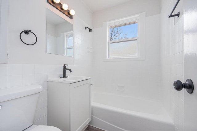 full bathroom featuring tub / shower combination, vanity, toilet, and tile walls