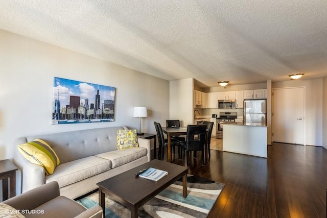 living area with a textured ceiling and hardwood / wood-style floors