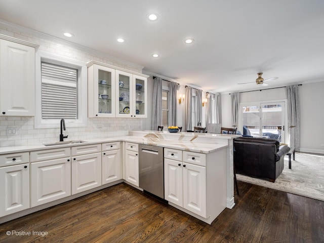 kitchen with dark wood-style flooring, white cabinets, a sink, dishwasher, and a peninsula