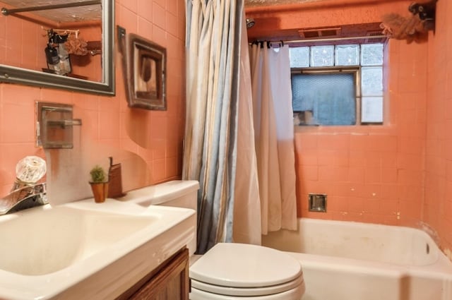 full bath featuring shower / tub combo, vanity, toilet, and tile walls