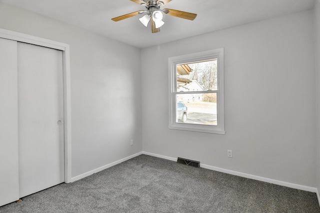 unfurnished bedroom featuring carpet floors, a closet, visible vents, and baseboards