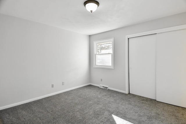 unfurnished bedroom with a closet, visible vents, baseboards, and carpet flooring