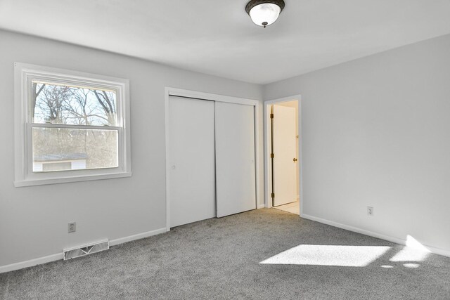 unfurnished bedroom featuring carpet, connected bathroom, visible vents, and baseboards