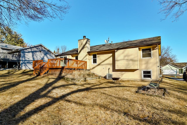 rear view of property featuring a chimney, a lawn, cooling unit, and a wooden deck