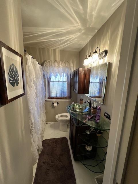 bathroom featuring tile patterned flooring, toilet, and vanity