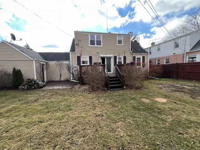 back of property featuring a yard, fence, and a wooden deck