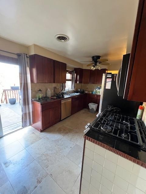 kitchen with a ceiling fan, visible vents, a sink, decorative backsplash, and dishwasher