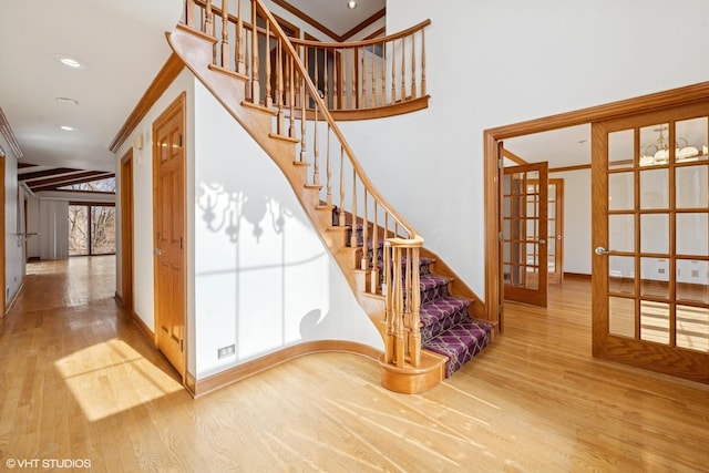 stairway featuring ornamental molding, french doors, and wood finished floors