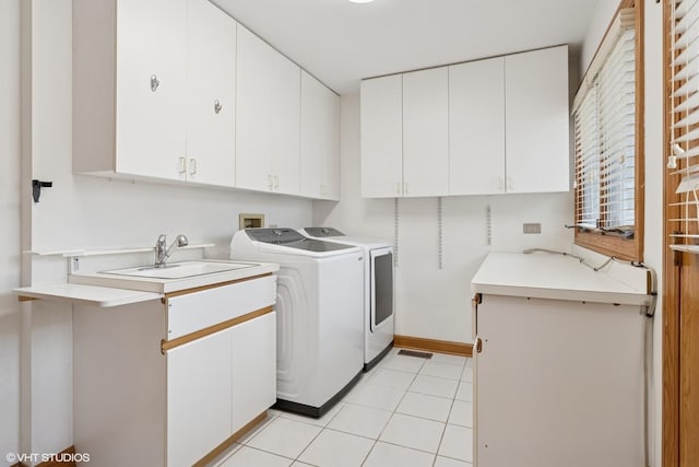 laundry room with cabinet space, light tile patterned flooring, a sink, and independent washer and dryer