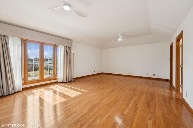 spare room with a ceiling fan, light wood-type flooring, lofted ceiling, and baseboards