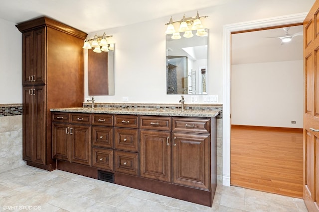 bathroom with wood finished floors, visible vents, a sink, and double vanity