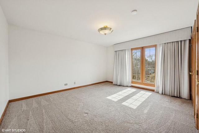 empty room featuring carpet and baseboards