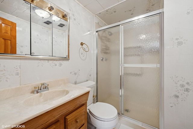 bathroom featuring a shower stall, toilet, and vanity