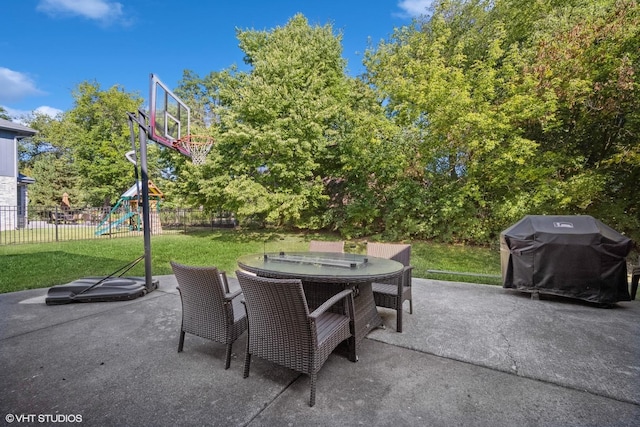 view of patio / terrace featuring outdoor dining area, a playground, a grill, and fence