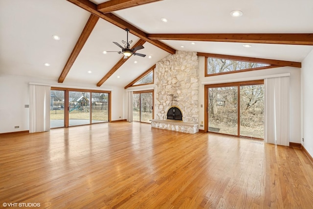 unfurnished living room with beam ceiling, ceiling fan, a stone fireplace, high vaulted ceiling, and light wood-type flooring