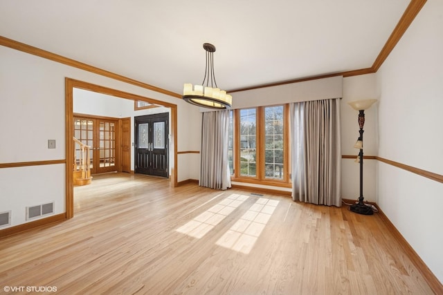 empty room featuring visible vents, french doors, wood finished floors, and ornamental molding