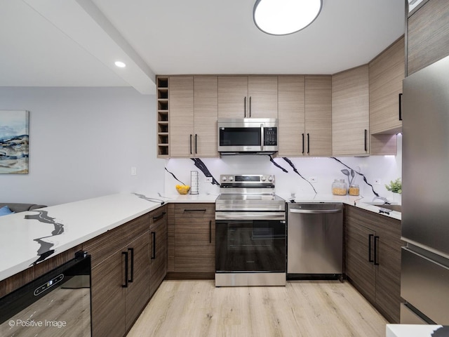 kitchen featuring modern cabinets, appliances with stainless steel finishes, light countertops, light wood-type flooring, and open shelves